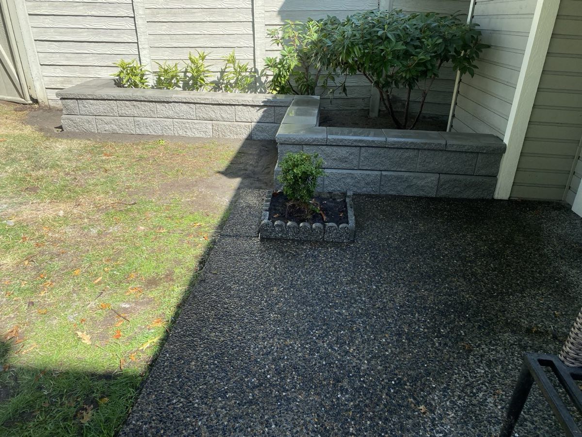 Block retaining wall and planter beside an aggregate patio